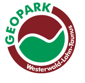 Logo des Geoparks Westerwald-Lahn-Taunus. Ein Kreis der durch eine geschwungene weiße Linie in eine braune und eine grüne Hälfte geteilt wird. Um den Kreis ist ein brauner Ring in dessen unterer rechter Hälfte in weiß die Worte Westerwald-Lahn-Taunus stehen. Der Ring wird in der oberen Linken Ecke durch das in grün geschriebene Wort Geopark geschlossen.
