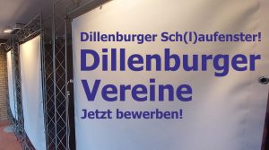 Eine Leinwand ist an einer Traverse gespannt. Darauf steht "Dillenburger Sch(l)aufenster! Dillenburger Vereine Jetzt bewerben!"