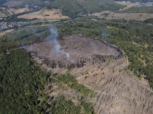 Eine Drohnenaufnahme des verbrannten Waldstückes bei Frohnhausen, von dem noch immer Rauch aufsteigt.