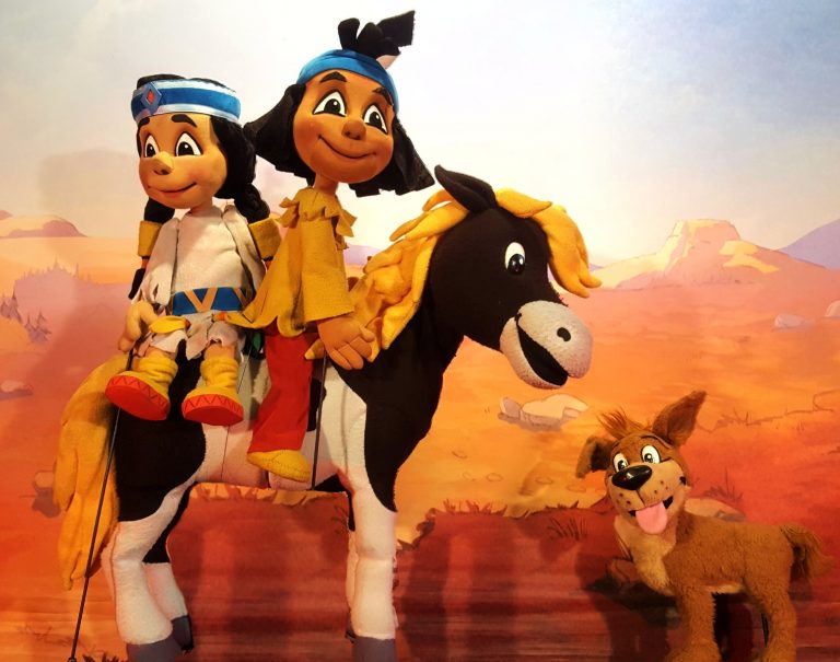 Das Bild dient auch als Navigationselement und führt zur Veranstaltungsbeschreibung des Figurentheaters Yakari. Das Bild zeigt den Indianerjungen Yakari, seine Freundin Regenbogen, sein schwarz-weißes Pony kleiner Donner und den Hund Knickohr als Figuren des Figurentheaters.