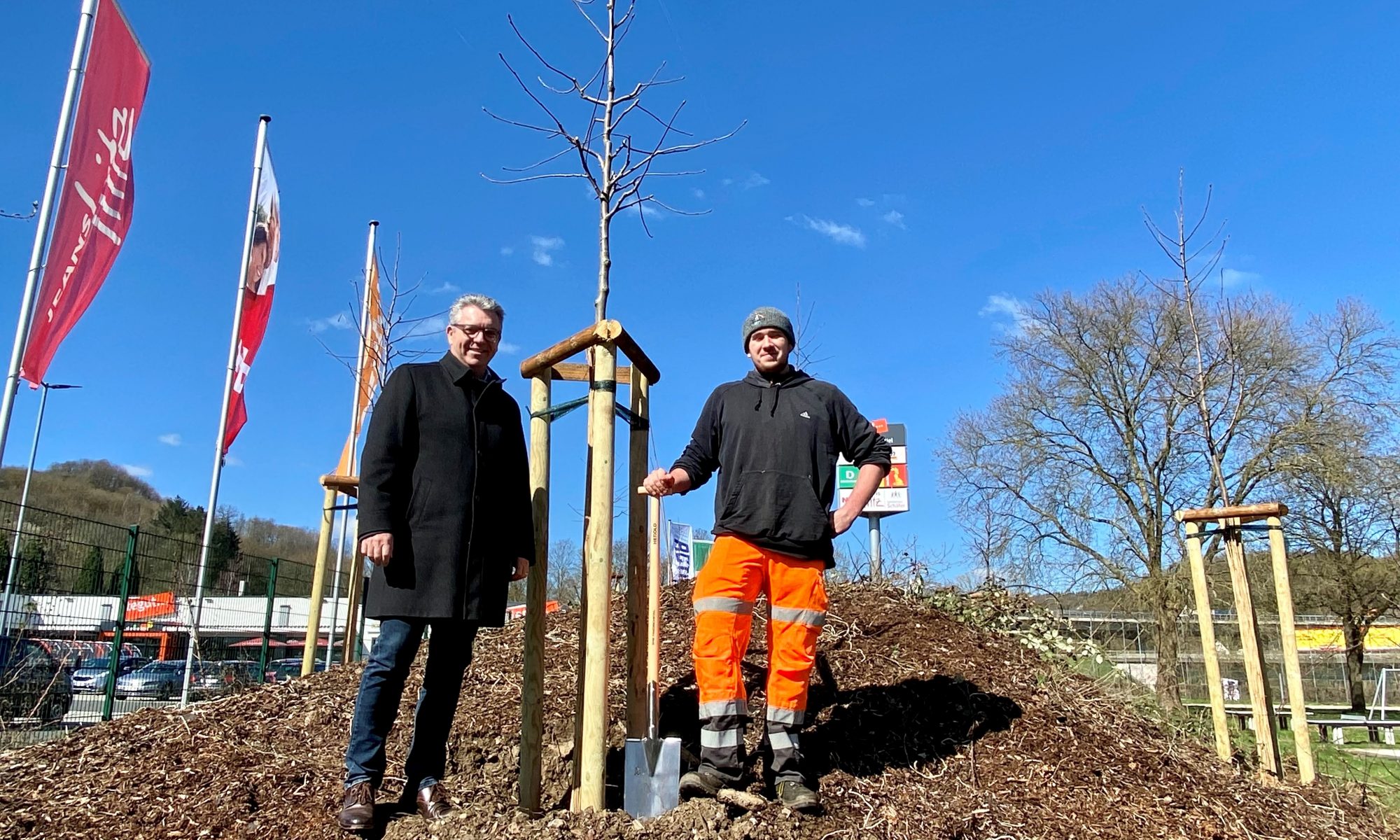 Bürgermeister Lotz und Gärtner-Auszubildender Corvin Bill zeigen neu gepflanzte Bäume