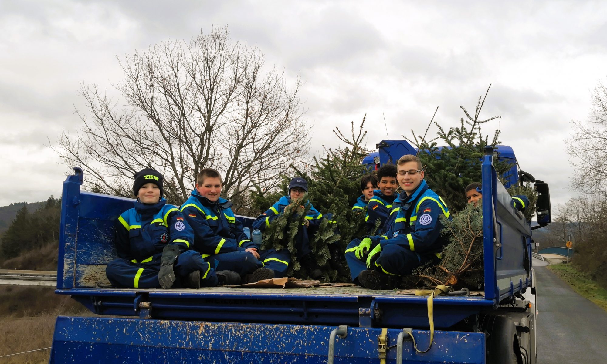 Jugendliche des THW und der Feuerwehr sammeln ausrangierte Weihnachtsbäume ein.