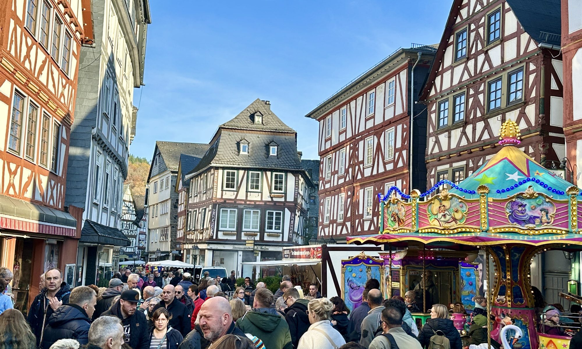 Ein Blick in die mit Ständen und Karussells bestandene Hauptstraße und die Besucher des Hubertusmarkts. Mit Klick aufs Bild geht´s zum ganzen Artikel.