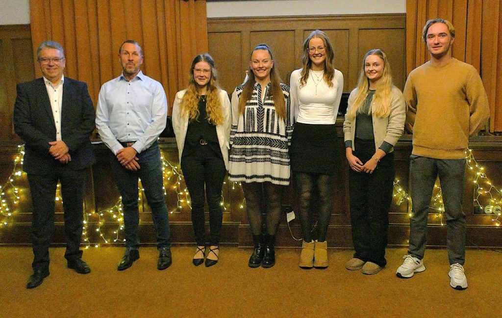 Bürgermeister Michael Lotz mit den sechs geehrten Sportlerinnen und Sportlern im Stadtverordnetensitzungssaal