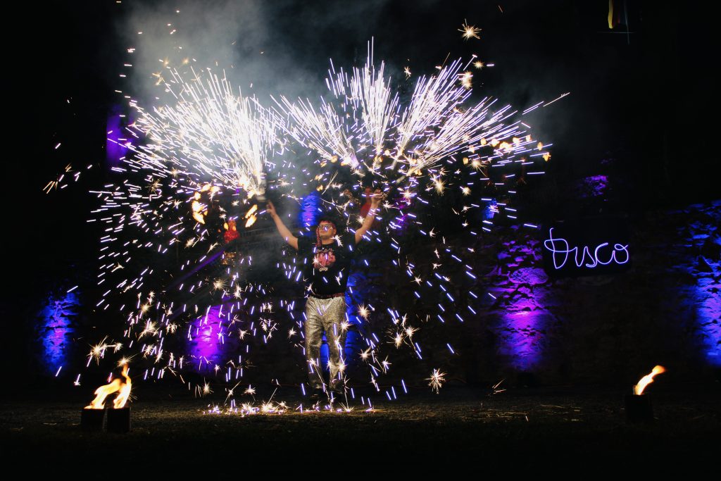 Ein Bild aus der Feuershow des Fähnleins zu Dillenburg. Eine Person mit funkensprühenden Fächern