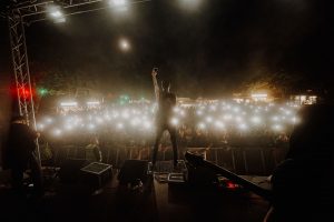 Sänger auf der Bühne, Publikum im Hintergrund. Mit Klick aufs Bild geht´s zum ganzen Artikel