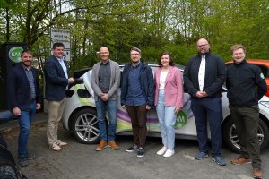 Menschen mit Auto an einer E-Ladesäule. Mit Klick aufs Bild geht´s zum ganzen Artikel