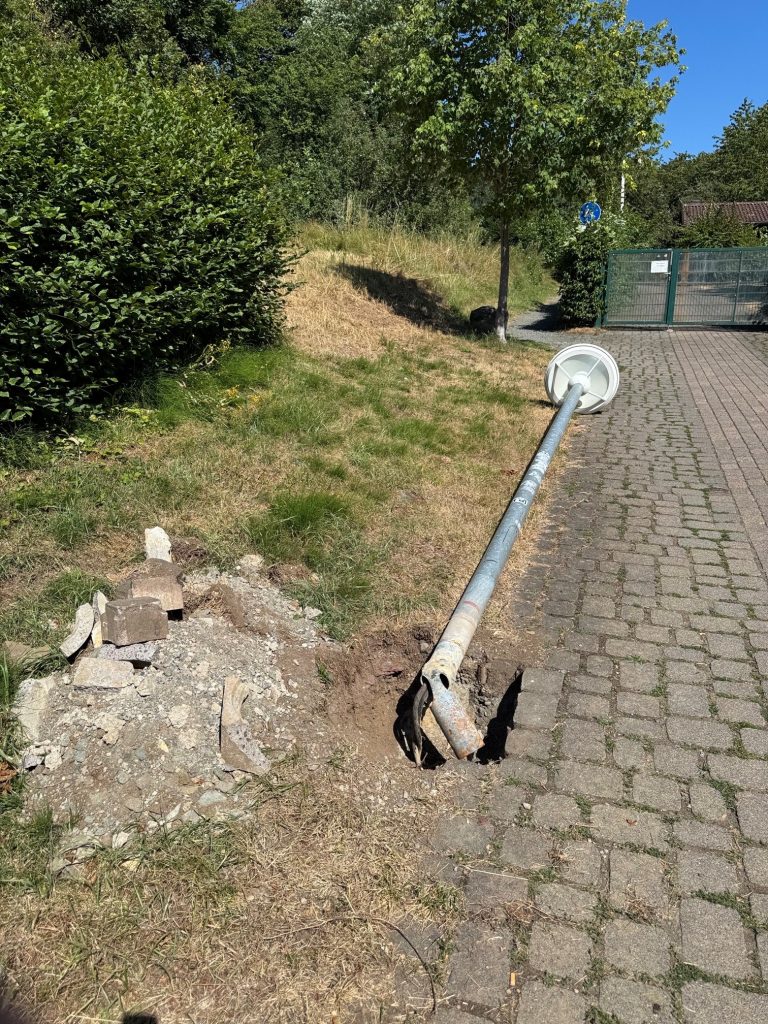 Zerstörte Straßenlaterne am Kindergarten Donsbach. Das Bild dient auch als Navigationselement und führt zum ganzen Artikel.
